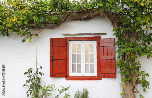 Valokuva fachada de casa con ventana roja en ascain pueblo vasco francés francia 4M0A7703
