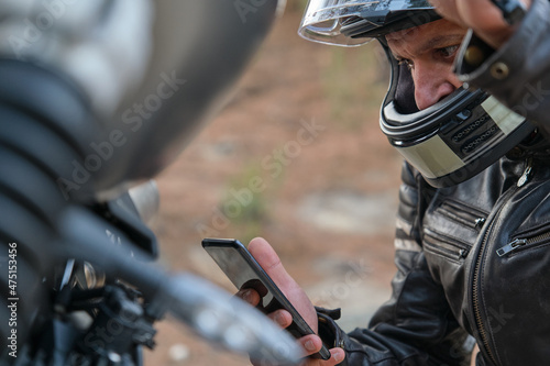 Worried motorcyclist calling motorcycle insurance with his cell phone