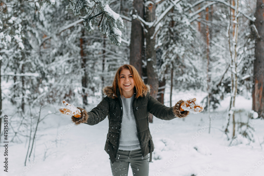 Snow in the air on the background of a blurry image of a happy young girl who throws white snow. Christmas holidays, Winter time
