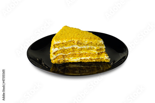 Piece of puff honey cake on black plate isolated on white background photo