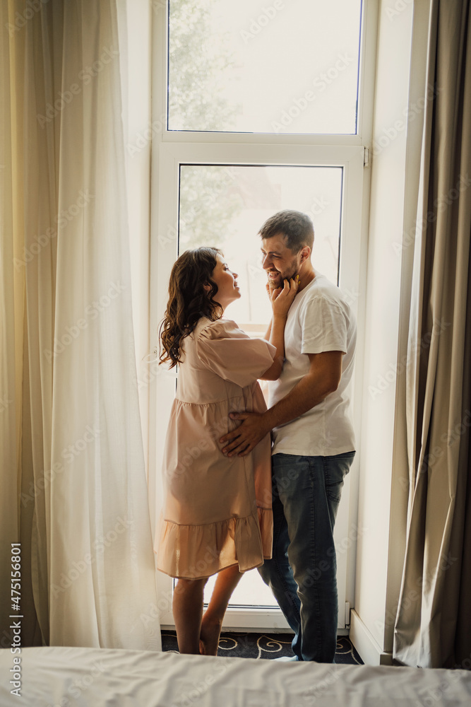 man and a pregnant woman's by the window. 