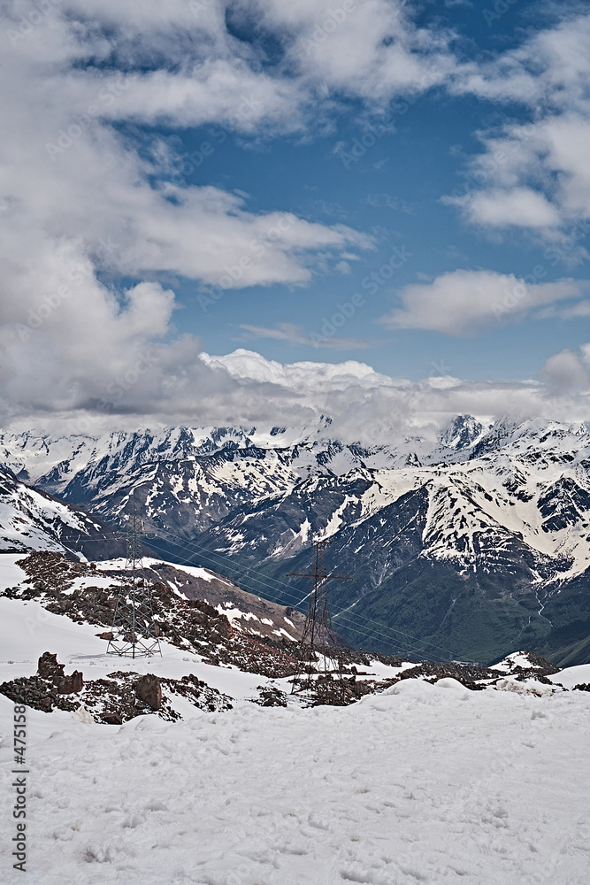 Elbrus mountains in May. Snow, greenery, brown earth