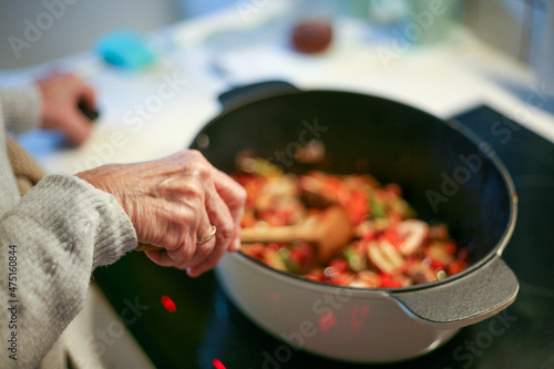 Kobieta gotująca i mieszająca jedzenie w brytfannie