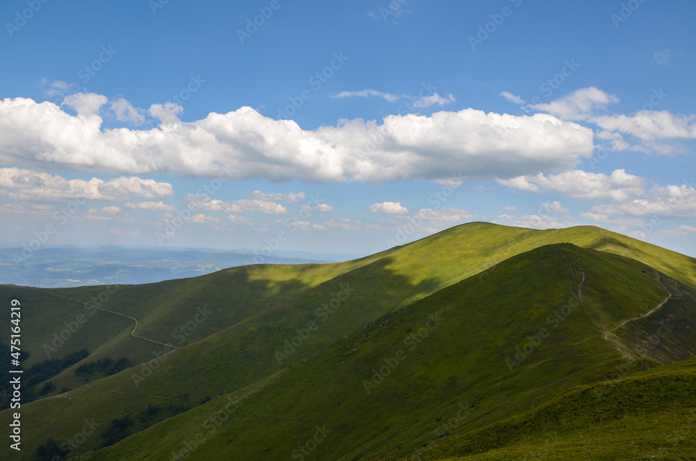 Hiking trail along the mountain range. Path through grassy alpine mountain slopes. Beautiful landscape of carpathians Ukraine