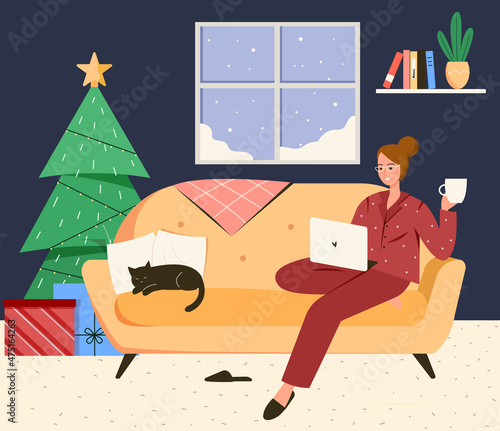 Woman in a pajamas working in a cozy room with christmas decoration