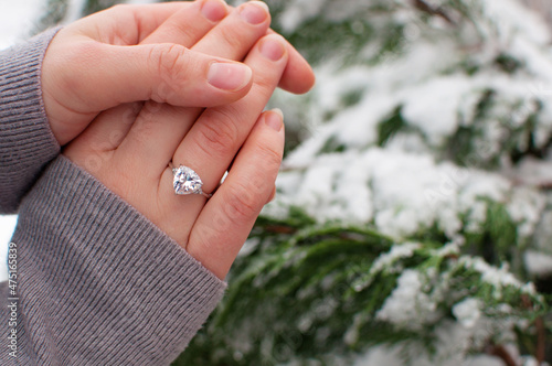 women's hands with a ring with a large gemstone on a blurred background with a place for text