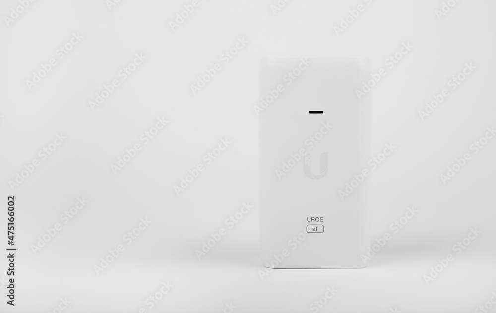 White PoE injector for electronic equipment on a white background White PoE injector for electronic equipment on a white background