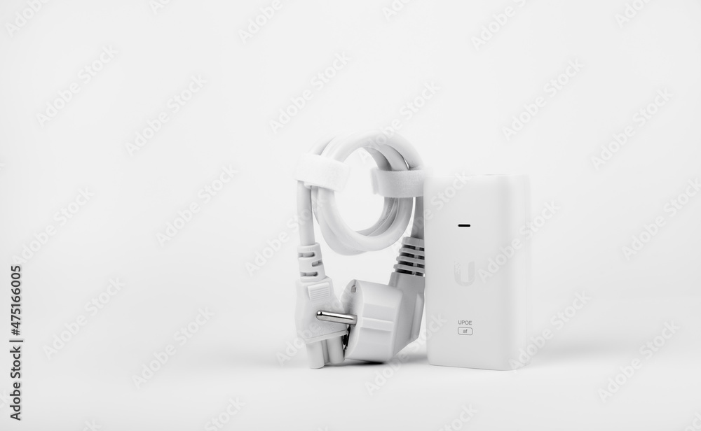 White PoE injector for electronic equipment on a white background White PoE injector for electronic equipment on a white background