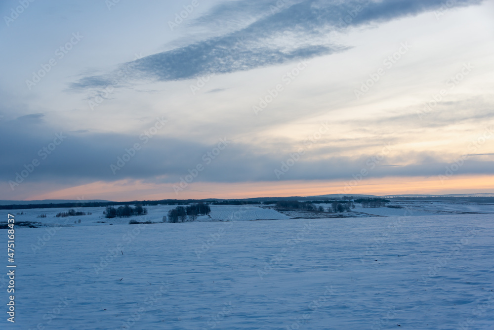 A field in the snow. Morning frosty sky at dawn.
