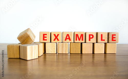 Example symbol. The concept word Example on wooden cubes. Beautiful wooden table, white background, copy space. Business and example concept.