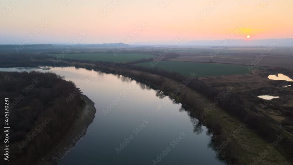 Aerial view of wide river flowing quietly in rural countryside in autumn evening Aerial view of wide river flowing quietly in rural countryside in autumn evening