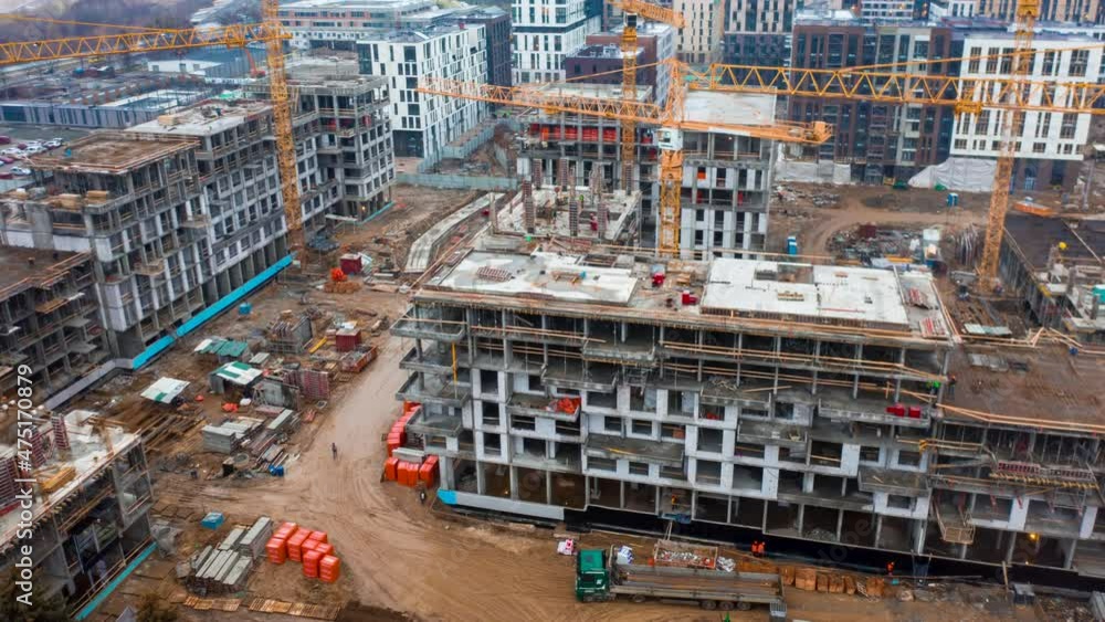 Aerial hyper lapse (hyperlapse - time lapse) of a large construction of a residential area with many multi-storey buildings under construction, a lot of tower cranes, workers, construction equipment Aerial hyper lapse (hyperlapse - time lapse) of a large construction of a residential area with many multi-storey buildings under construction, a lot of tower cranes, workers, construction equipment
