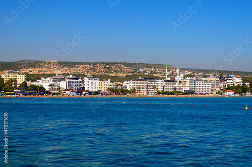 Kizkalesi, Turkey-11 October, 2021:Wide angle landscape view of blue water of Mediterranean Sea and city beach, embankment with many hotels in Kizkalesi. Blue sky background. Famous touristic place