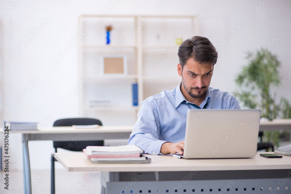 Young male employee working in the office Young male employee working in the office