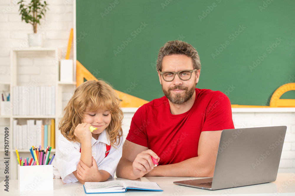 dad and son study in classroom with laptop, school online