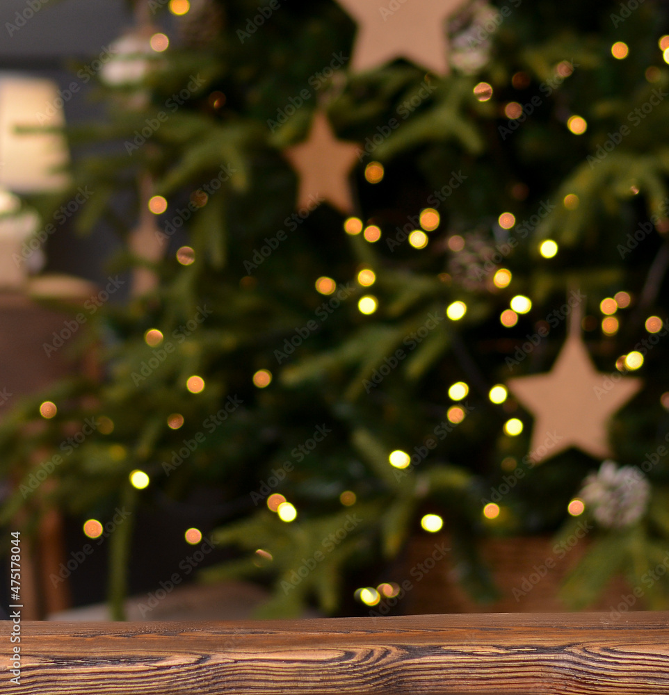 Christmas background. Empty wooden table on the background of the Christmas tree and New Year's bokeh.Ready for product montage.