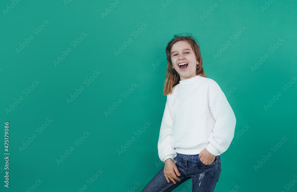 a small, beautiful girl screams loudly with her mouth wide open on a green isolated background. a small, beautiful girl screams loudly with her mouth wide open on a green isolated background.