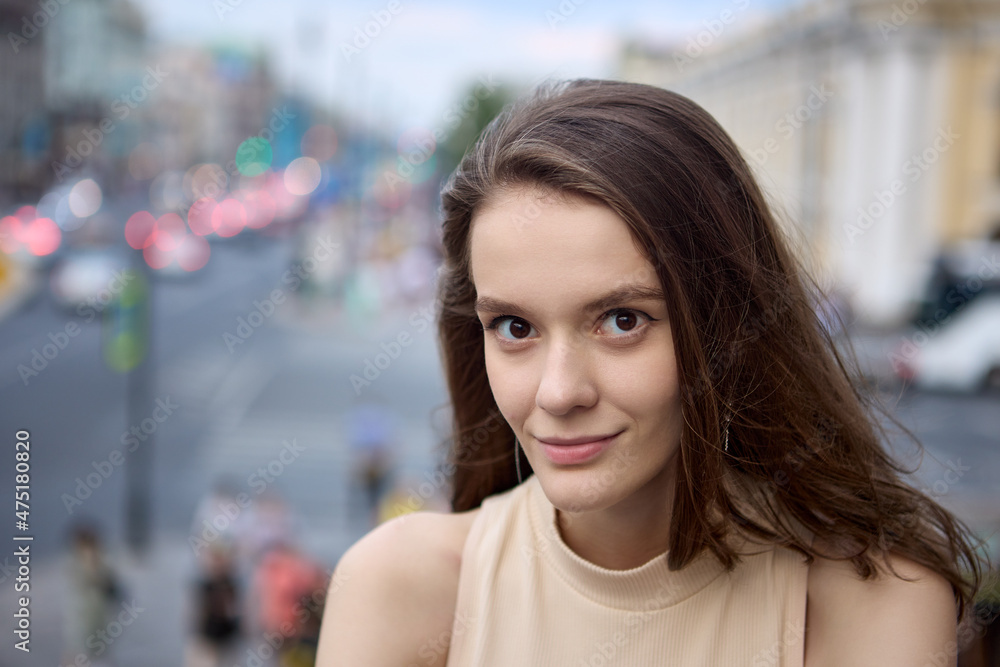 Defocused street in center of large city and woman portrait in front of it.