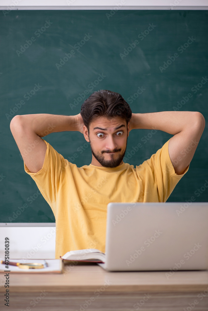 Young male student in telestudying concept Young male student in telestudying concept