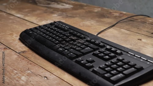 Sledge hammer hitting computer keyboard. Damage keyboard. Broken office equipment. Old computer keyboard with smashed buttons. Garbage concept.