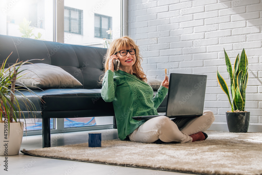 Obraz premium woman at home with mobile phone and computer buying online