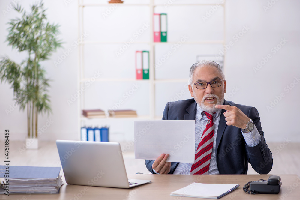 Old male employee working in the office Old male employee working in the office