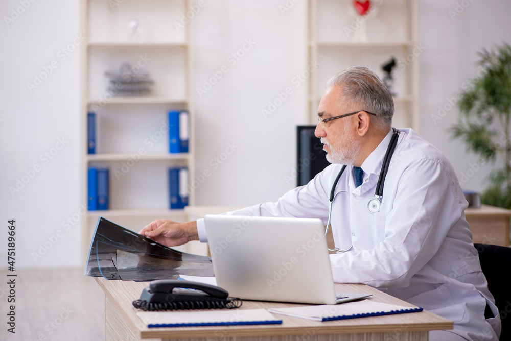 Old male doctor radiologist working in the clinic Old male doctor radiologist working in the clinic