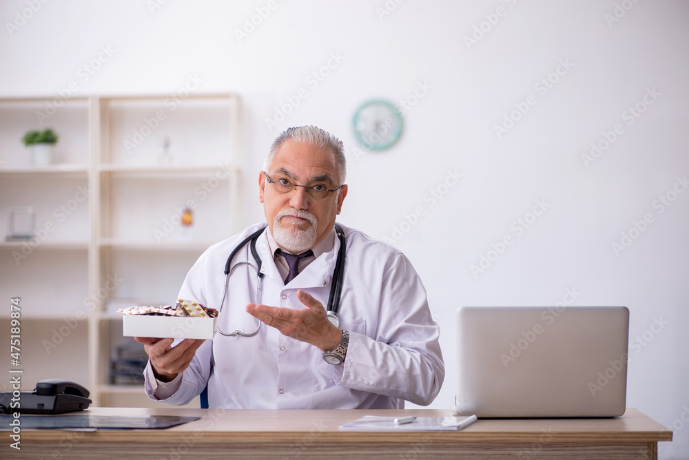 Old male doctor working at the hospital Old male doctor working at the hospital