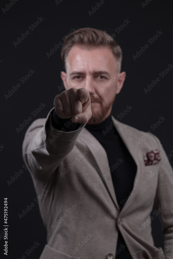 Portrait of a stylish elegant senior businessman with a beard and casual business clothes in photo studio isolated on dark background gesturing with hands Portrait of a stylish elegant senior businessman with a beard and casual business clothes in photo studio isolated on dark background gesturing with hands