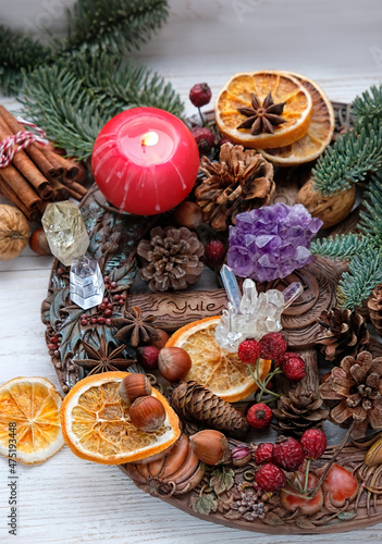 traditional Wiccan altar for Yule sabbath. Wheel of the year, candle, minerals, cinnamon sticks, nuts, cones, dry orange slices. Esoteric Ritual for Christmas, Yule, Magical Winter Solstice.