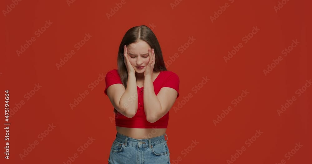 Upset young girl with facepalm gesture, feeling shame because of failure, mistake or bad memory on orange background Upset young girl with facepalm gesture, feeling shame because of failure, mistake or bad memory on orange background