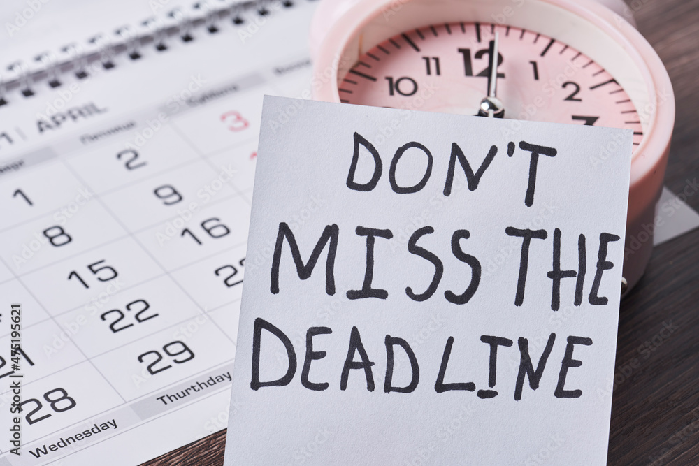 Dont miss the deadline. Deadline text on piece of paper, alarm clock and monthly calendar on the desk. White card with Deadline text and last date of month. Last day, Last chance concepts Dont miss the deadline. Deadline text on piece of paper, alarm clock and monthly calendar on the desk. White card with Deadline text and last date of month. Last day, Last chance concepts