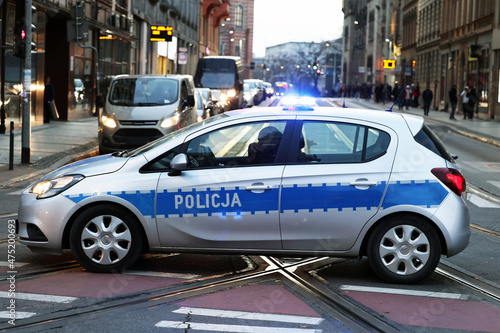 Polscy policjanci i ich pojazdy podczas wieczornej służby w mieście. 