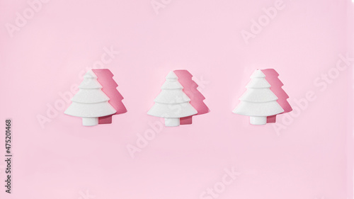 Three geometrical white Christmas trees on pastel pink background. Minimal romantic composition for Christmas or New Year's eve celebration or web banner © Miss V