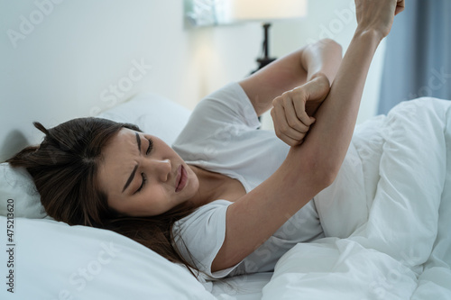 Asian young woman scratch hand feel suffer from allergy while sleeping photo