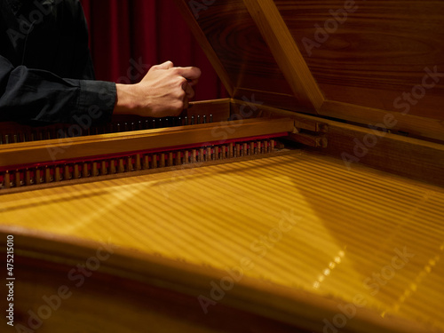 Musician tunes historical harpsichord cembalo with his hands before the concert. photo