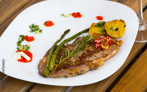 Homemade veal steak with grilled zucchini, tomato, asparagus