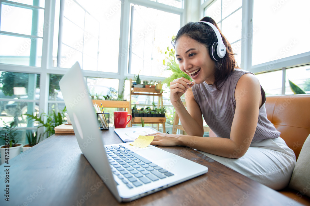 Asian businesswomen is using notebook computers and wear headphones for online meetings and working from home. Asian businesswomen is using notebook computers and wear headphones for online meetings and working from home.