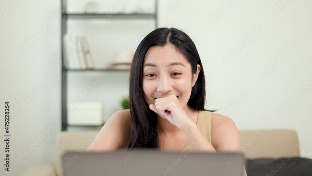 Beautiful asian woman using laptop chatting video conference online sitting in living room at home. Business Woman looking at screen Meeting on social media. Work from home. Beautiful asian woman using laptop chatting video conference online sitting in living room at home. Business Woman looking at screen Meeting on social media. Work from home.
