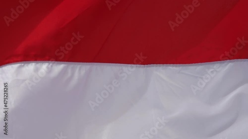 Red and white real flag flying by wind. photo