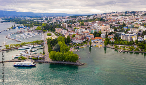 View from drone of lake Leman and houses of swiss city Lausanne in cloudy summer day