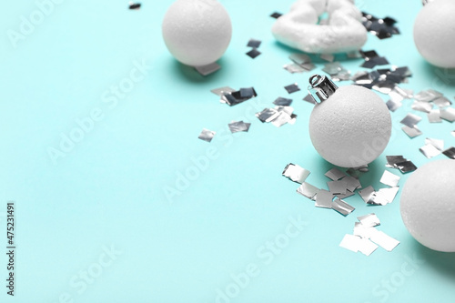 White Christmas decorations and confetti on blue background  closeup