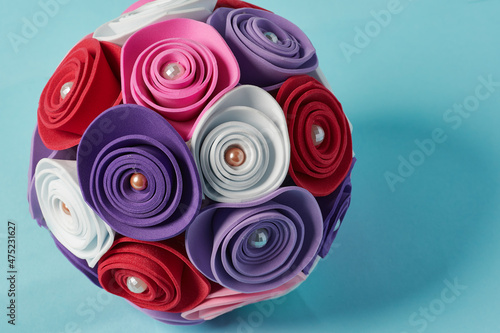 Rose sphere made of white, purple, red and pink foami on a blue background. Multicolored abstract object. photo