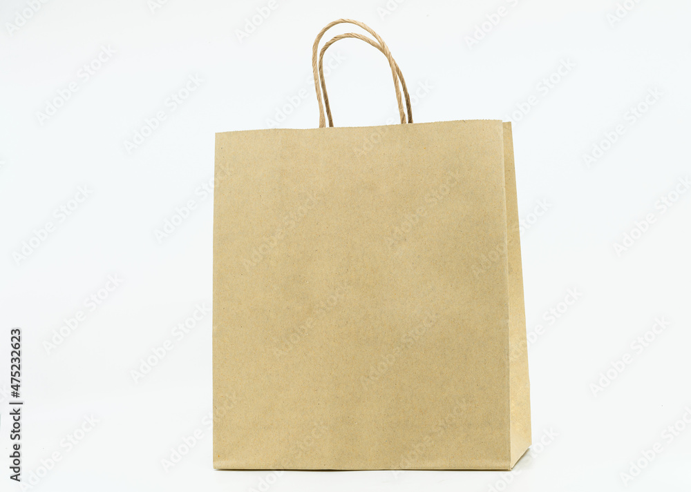 Isolated brown paper bag on white background, brown paper bag with paper handle, blank space on the front for design elements. Isolated brown paper bag on white background, brown paper bag with paper handle, blank space on the front for design elements.