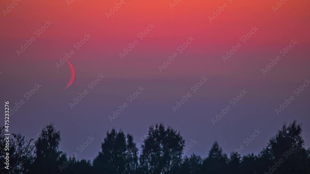Cinematic beautiful shot of sunset of the moon captured in the mild orange evening turning night in the sky in a exciting view with the trees down on the ground shaking in the cool breeze. Cinematic beautiful shot of sunset of the moon captured in the mild orange evening turning night in the sky in a exciting view with the trees down on the ground shaking in the cool breeze.