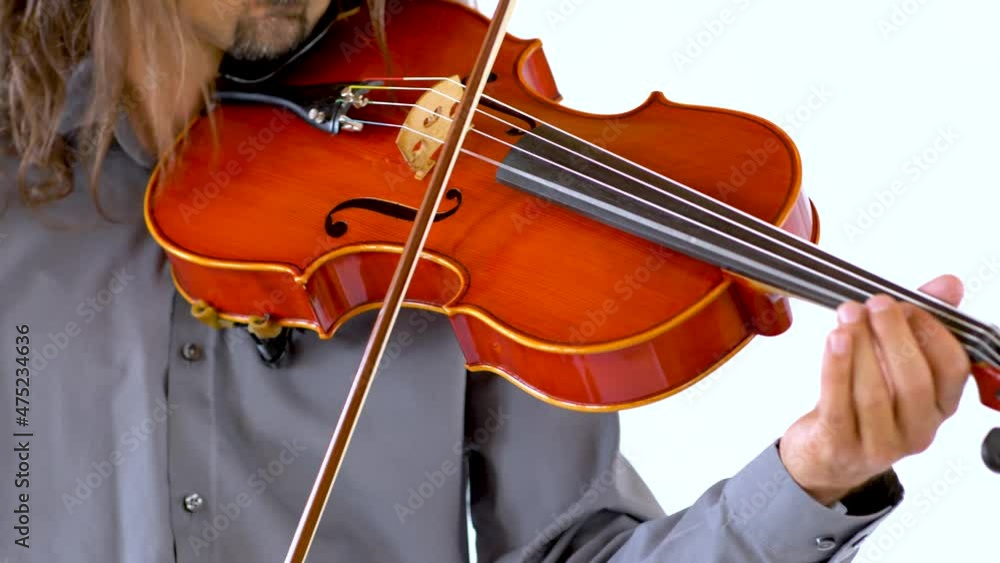 Close up of long hair ethnic musician in grey button up shirt playing red viola against white backdrop Close up of long hair ethnic musician in grey button up shirt playing red viola against white backdrop
