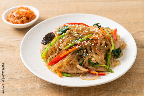 japchae or stir-fried Korean vermicelli noodles with vegetables and pork topped with white sesame