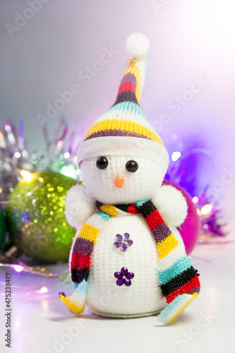 Knitted snowman on the background of Christmas toys