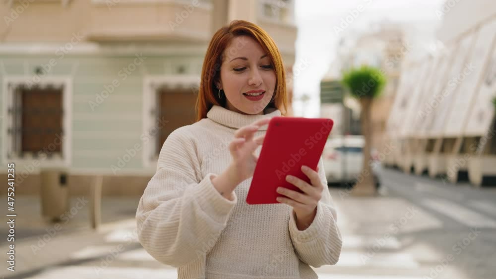Young redhead woman smiling confident using touchpad at street Young redhead woman smiling confident using touchpad at street