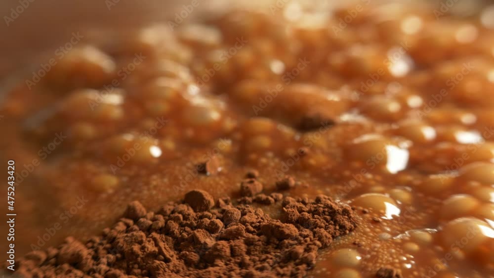Boiling caramel with dry cocoa powder on top. Close up. Boiling caramel with dry cocoa powder on top. Close up.